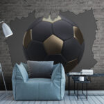 Papier peint Un ballon de football traverse un mur de briques