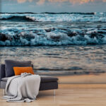 Papier peint Les vagues dansent sous le soleil levant.